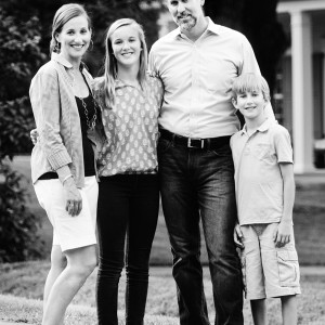 Black and white photo of the Henderson family standing in front of their front yard.